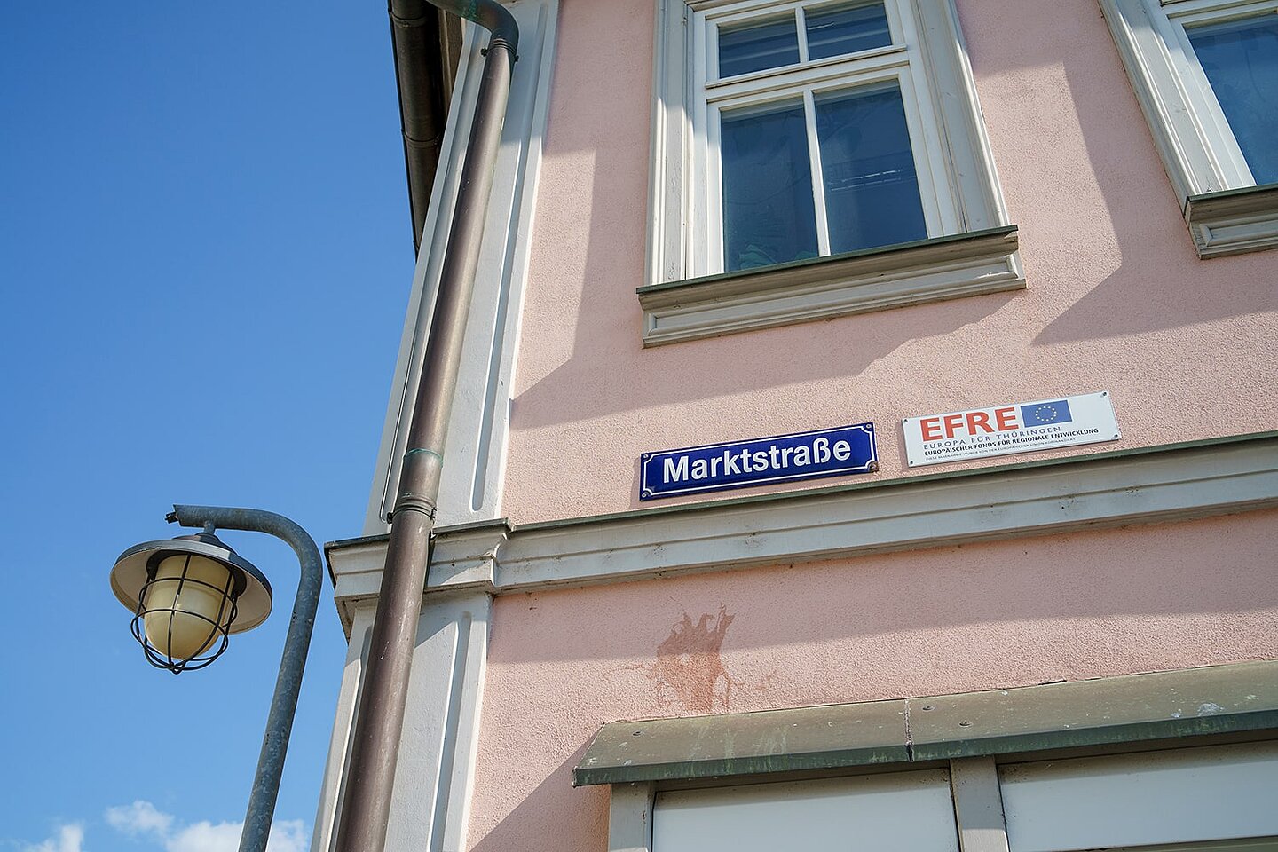 Ein Straßenschild mit der Aufschrift Marktstraße. Daneben ein Schild mit dem Emblem der EU und der Aufschrift EFRE