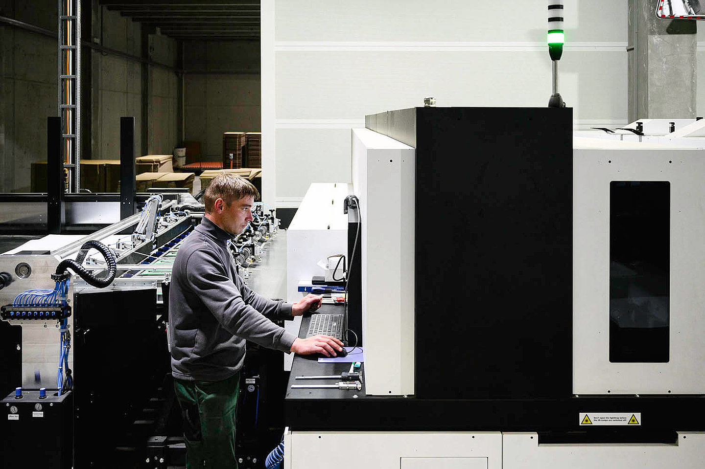 Ein Mann bedient eine sehr große Laserschneider-Maschine