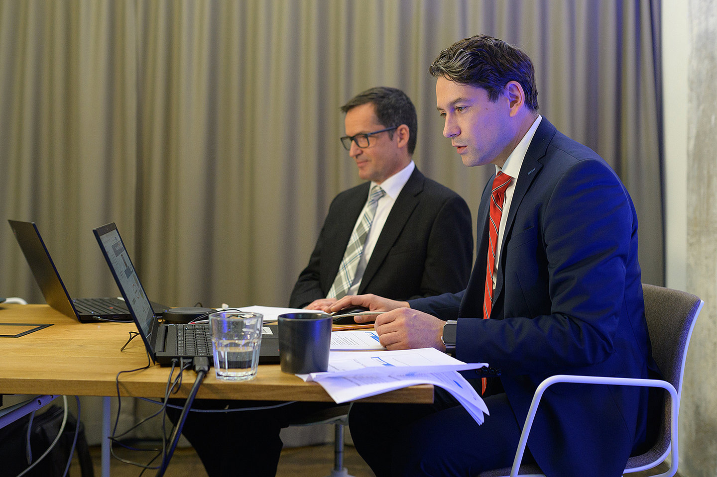 Robert Fetter (TMWWDG) und Dr. Klaus Dahnke (TMWWDG) sitzen an einem Tisch und schauen auf Laptops